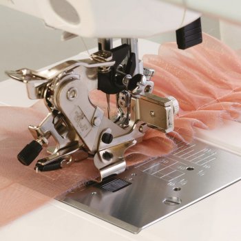 Janome rynk- och plisseapparat monterad på en symaskin med ett rosa veckat tyg