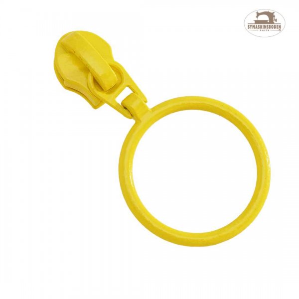 En gul kläpp med ring till spiralblixtlås på metervara.