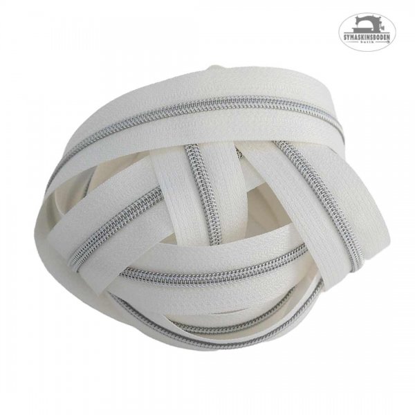 en ihoprullad bunt med blixtlas pa vit metervara i silver