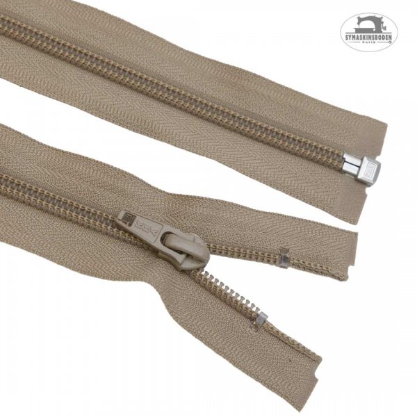 Ett blixtlås till jackor och tjocktröjor i beige färg.