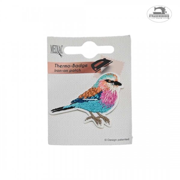 tygtmärke i form av en fin fågel i rosa, blått och orange