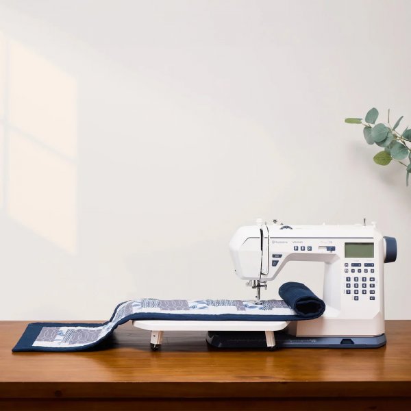 Tyg ligger på ett monterat sybord på en Husqvarna Onyx 30