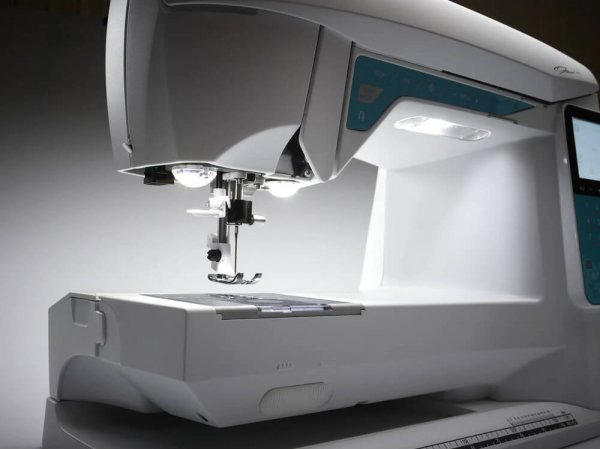 Detaljvy av nålområdet på Opal 650 som visar de tre kraftfulla LED-lamporna. Belysningen ger ett skuggfritt arbetsljus över den