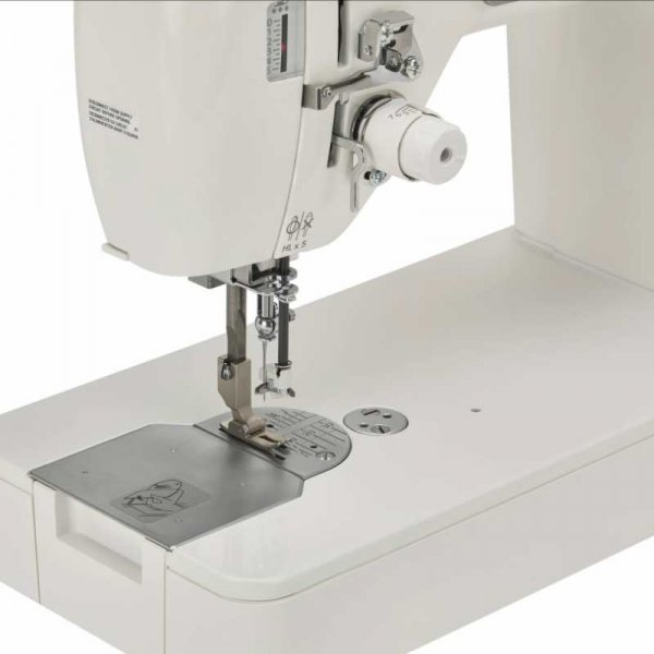 Janome HD9QCP; närbild på pressarfot och stygnplåt på det stabila plana arbetsbordet.