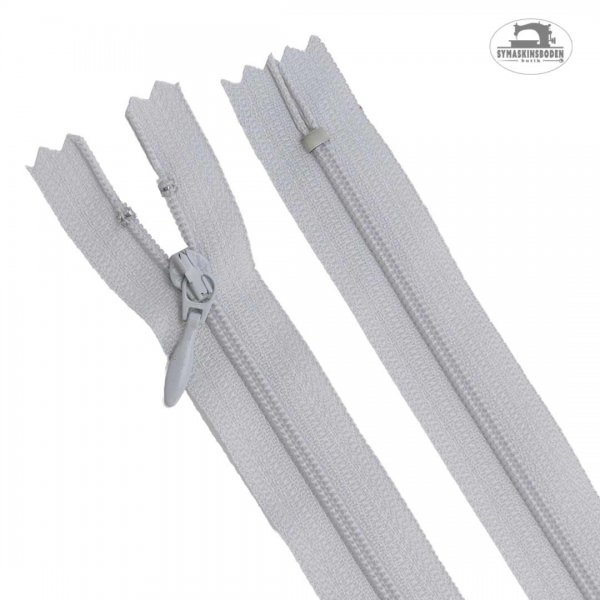 Ett ljusgrått blixtlås till kjol och klänning som är 25 cm långt