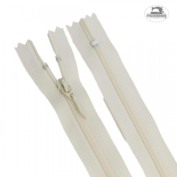 En 25 cm lång dragkedja till klänning och kjol i färgen benvit.